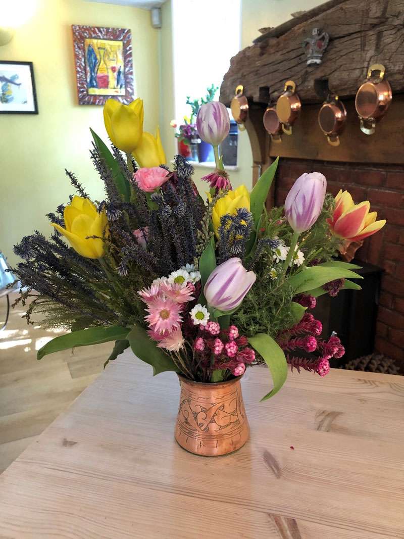 Each table has a vase of freshly cut flowers