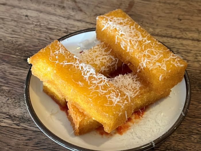 Side dish of polenta chips served with the chicken breast