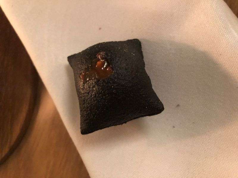 An introductory black pudding snack with pickled gooseberry